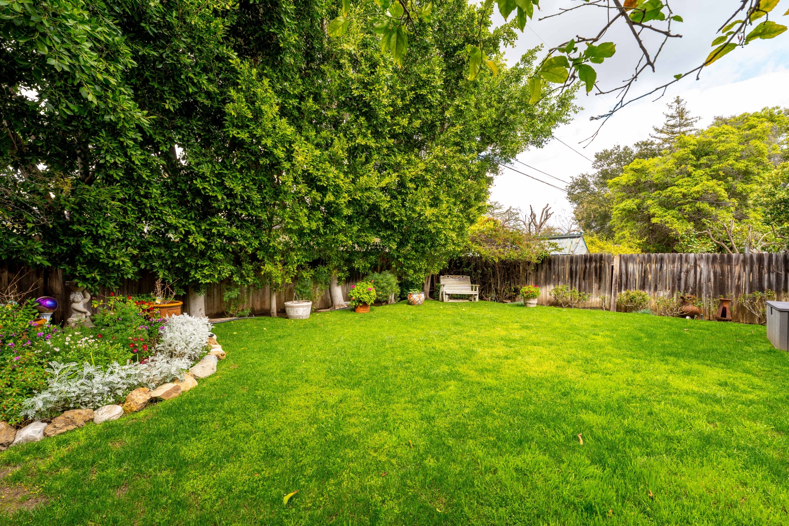 11323 Valley Spring Lane - beautiful backyard with beautify green grass, wooden fence and white bench in a corner