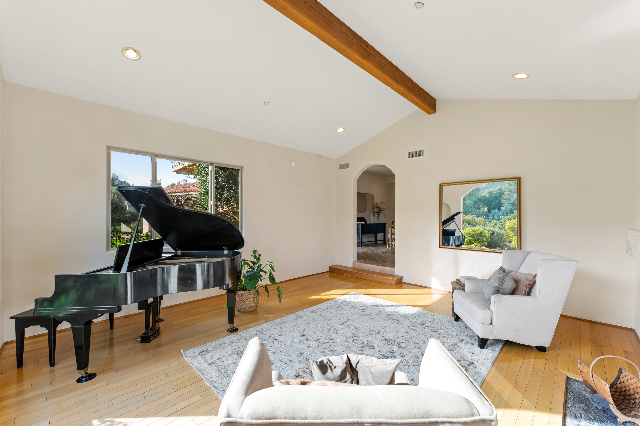 Cozy living room with armchairs, black piano with wall mirror at 2175 Cold Canyon Road Calabasas
