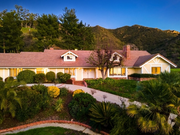 property listing compound view with beautiful flowers and mountain view behind in 24592 Mulholland Highway